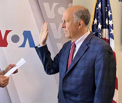 Photo of Michael Abramowitz raising his hand as he is sworn in to his new role.