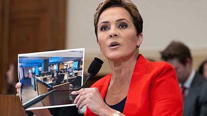 Screenshot of Kari Lake holding up a photo of VOA's Central Newsroom during her congressional testimony.