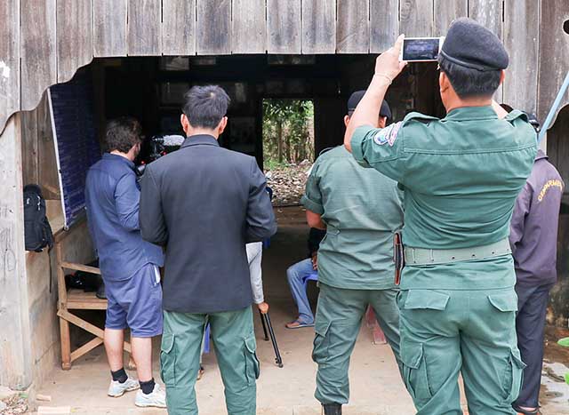 Cambodian military police officers use their cell phones to record a VOA interview.