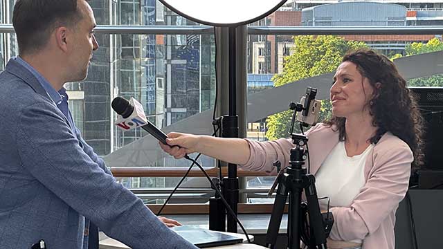 Photo of a VOA reporter holding a microphone while interviewing Alexey Arestovich, Advisor to the Office of the President of Ukraine.