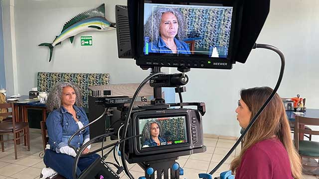 VOA journalist Cristina Caicedo Smit films an interview with a Mexico crime scene photographer.